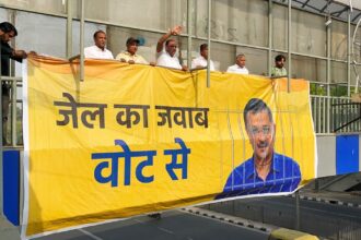 Aam Aadmi Party supporters install a poster in support of Delhi CM and party national convener Arvind Kejriwal, at ITO foot over bridge in New Delhi on Friday. Delhi CM was earlier arrested by ED in the alleged excise policy scam case.