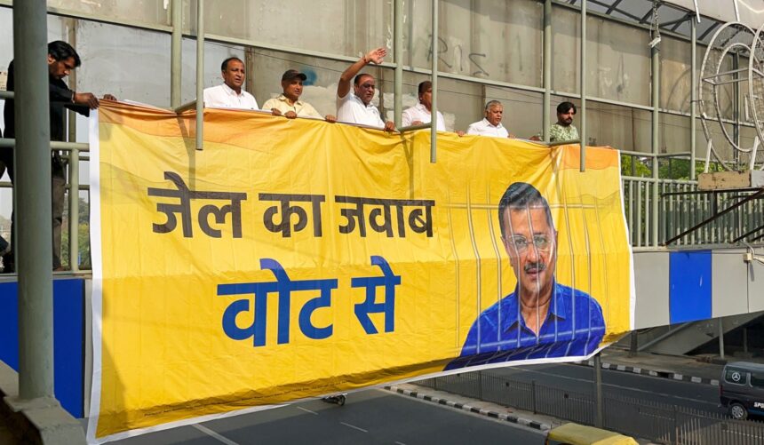Aam Aadmi Party supporters install a poster in support of Delhi CM and party national convener Arvind Kejriwal, at ITO foot over bridge in New Delhi on Friday. Delhi CM was earlier arrested by ED in the alleged excise policy scam case.